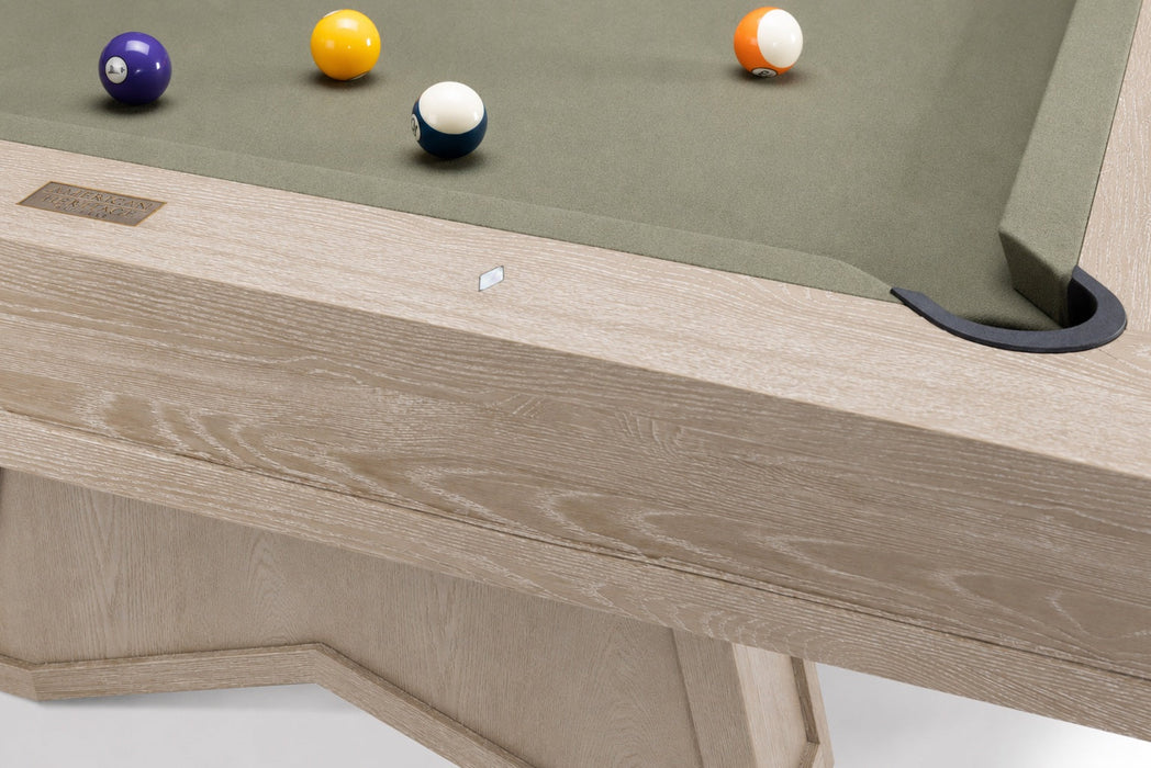 Close-up of a wooden pool table showing the light oak frame, green felt surface, and several billiard balls on a white background.
