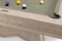 Close-up of a wooden pool table showing the light oak frame, green felt surface, and several billiard balls on a white background.