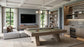 A modern pool table in a spacious, contemporary home bar and living room setting with a sectional sofa, TV, bookshelves, and a wine cooler.