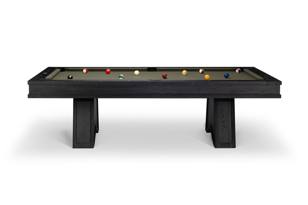 A modern pool table with a dark charcoal wood frame and legs, featuring a green felt surface with various billiard balls arranged on it, set against a plain white background.