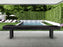 American Heritage Lanai 12' Obsidian Black shuffleboard table by the pool and lounge area.