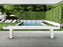 American Heritage Lanai 9' Outdoor Shuffleboard Table in Pearl White by patio, pool, and garden.