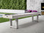 An American Heritage Lanai 12' Pearl White shuffleboard sits by the patio’s fireplace and garden.