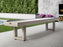 The American Heritage Lanai 9' shuffleboard in Oyster Grey sits on a patio near the garden.