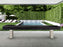A modern pool area with Oyster Grey lounge chairs and an American Heritage Lanai shuffleboard.